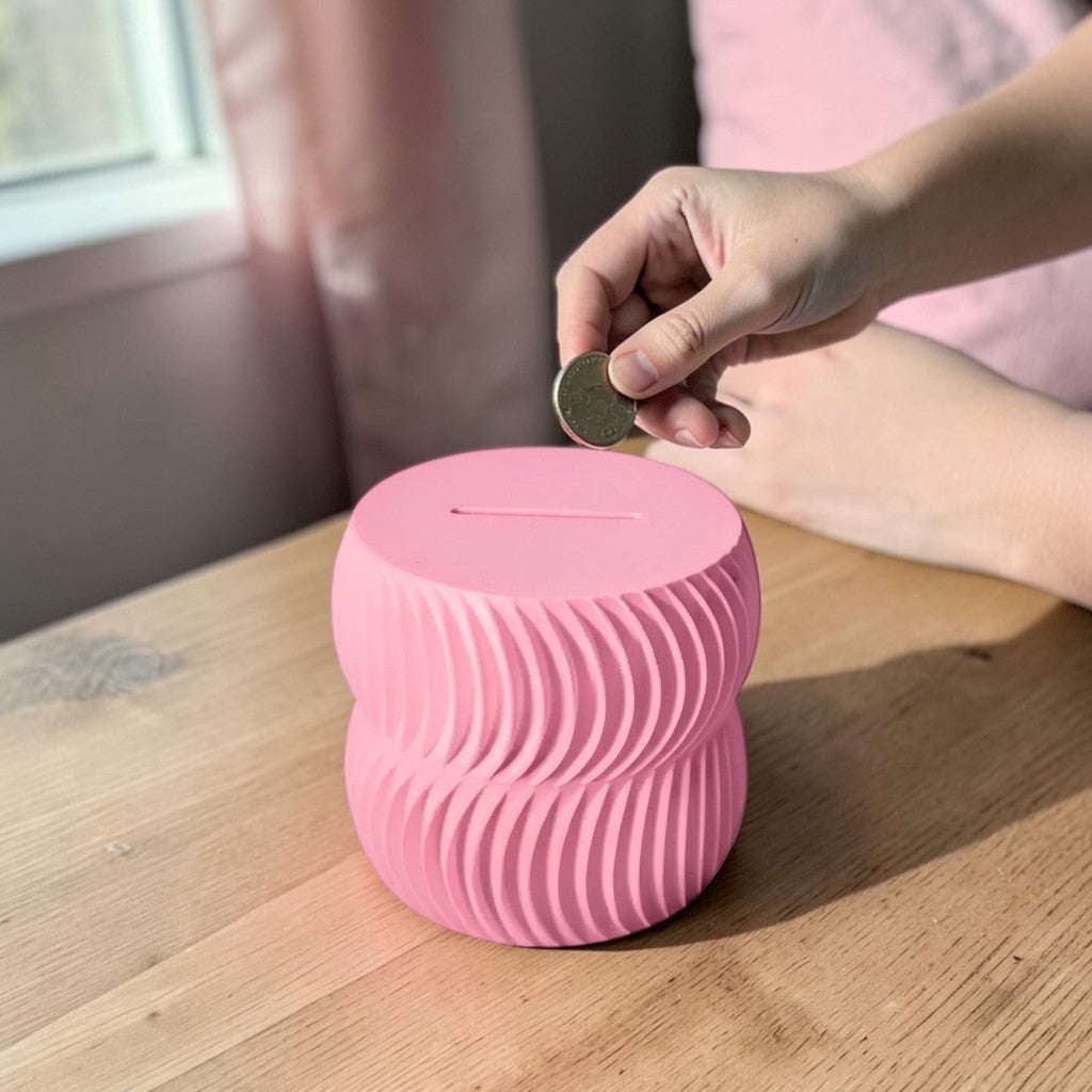 A modern 3D-printed coin bank with a sleek, openable design, available in two sizes. Perfect for storing coins and cash securely while adding a stylish touch to any home or office. Ideal for kids, adults, and as a unique gift for savers.