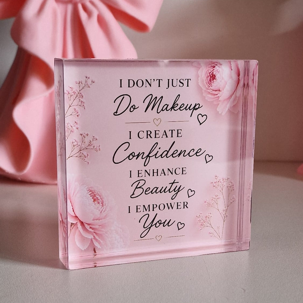 Pink decorative block with motivational quote on a light gray surface