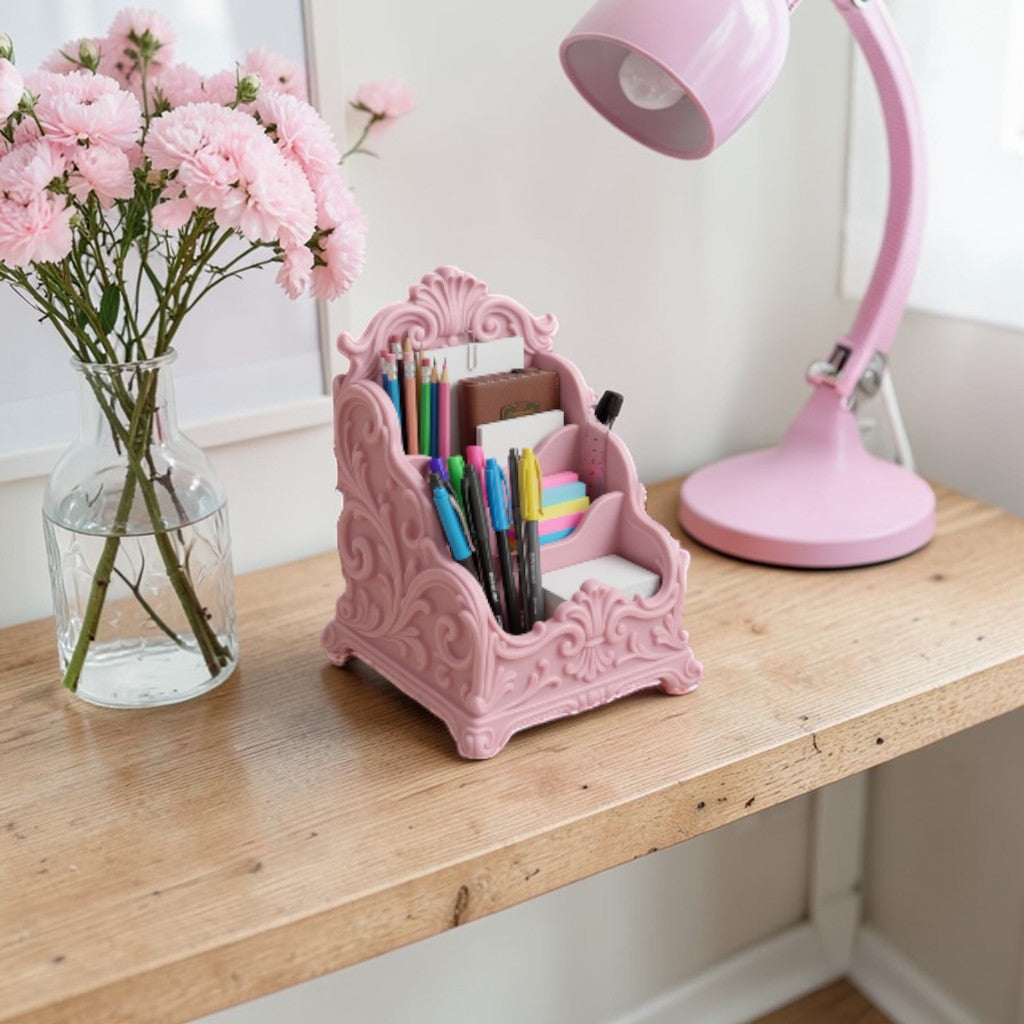 Pink baroque desk organizer with rococo detailing, used as a makeup brush holder and letter organizer on a luxury home office desk.