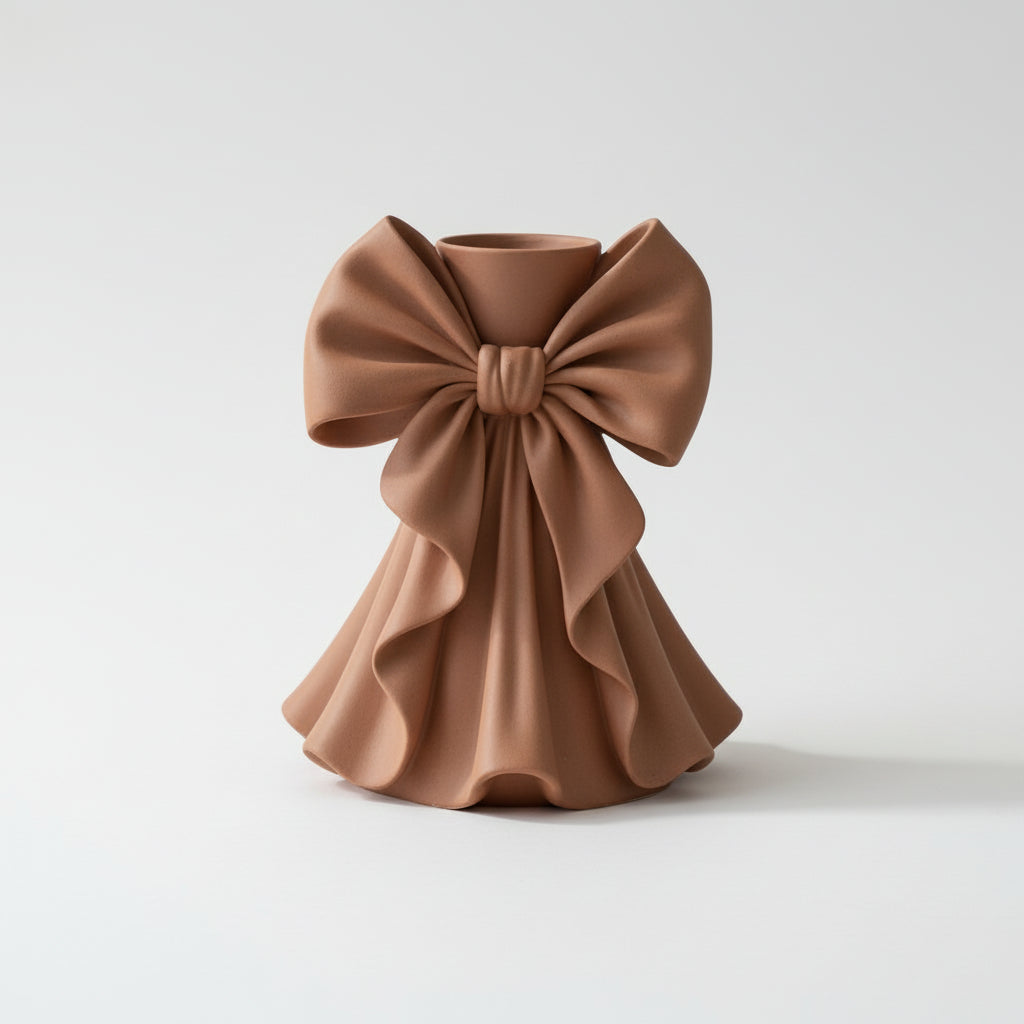 Coquette bow vase with pleated fabric-style design in soft pink on a vanity table
Romantic bow flower vase styled with roses and feminine home decor
Sculptural bow vase with matte finish for bridal and coquette interiors
Feminine decorative vase with gift-inspired silhouette and elegant bow
 Soft aesthetic flower vase designed for romantic and luxury spaces