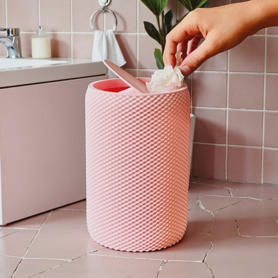 Pink vanity bin with textured design placed on wooden vanity table