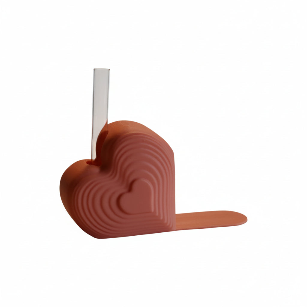Pink heart bookend that doubles as a test tube vase, styled on a desk with books; romantic shelf decor and Valentine’s gift for book lovers.