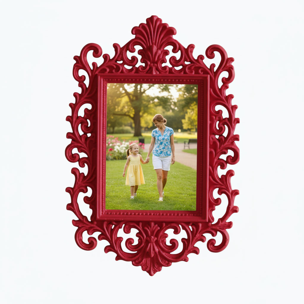 May include: A decorative pink picture frame with an elaborate, swirling design. The frame contains a photograph of a woman and child in a park. The frame is on a white shelf, with pink flowers and a candle.