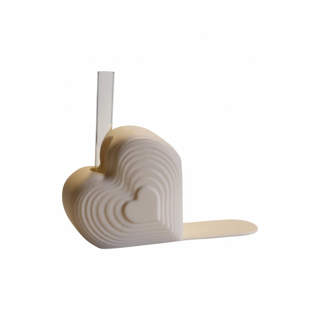 Pink heart bookend that doubles as a test tube vase, styled on a desk with books; romantic shelf decor and Valentine’s gift for book lovers.