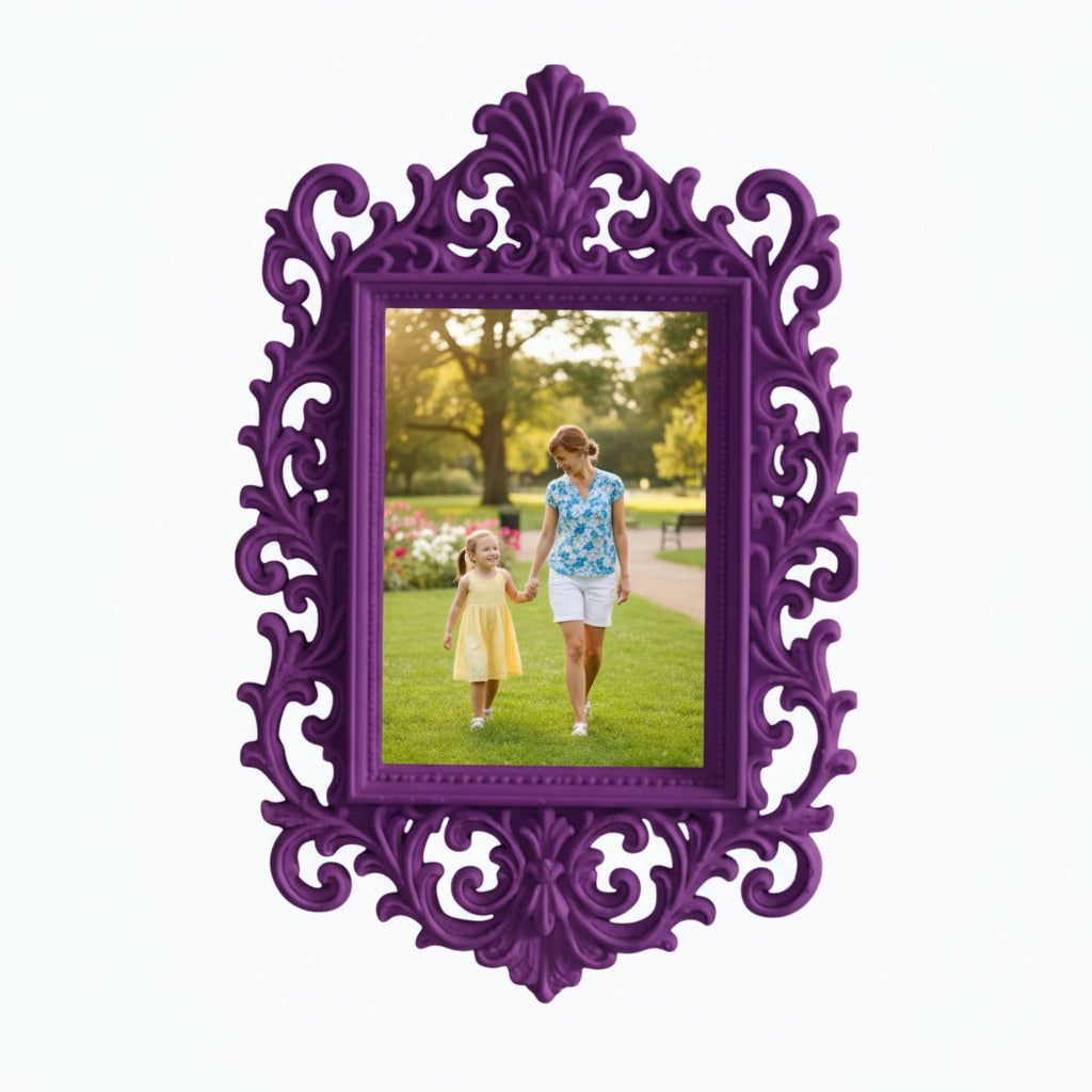 May include: A decorative pink picture frame with an elaborate, swirling design. The frame contains a photograph of a woman and child in a park. The frame is on a white shelf, with pink flowers and a candle.