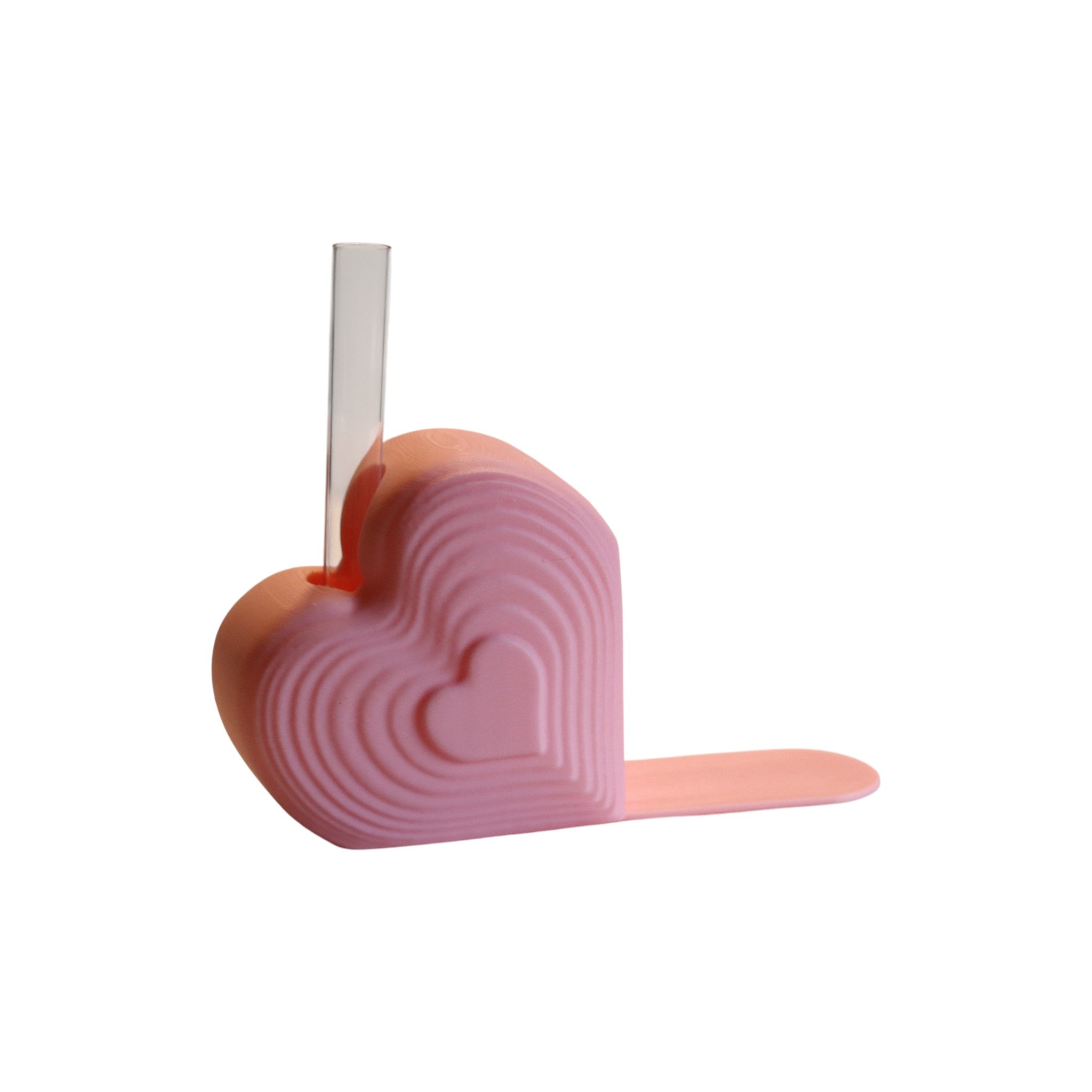 Pink heart bookend that doubles as a test tube vase, styled on a desk with books; romantic shelf decor and Valentine’s gift for book lovers.